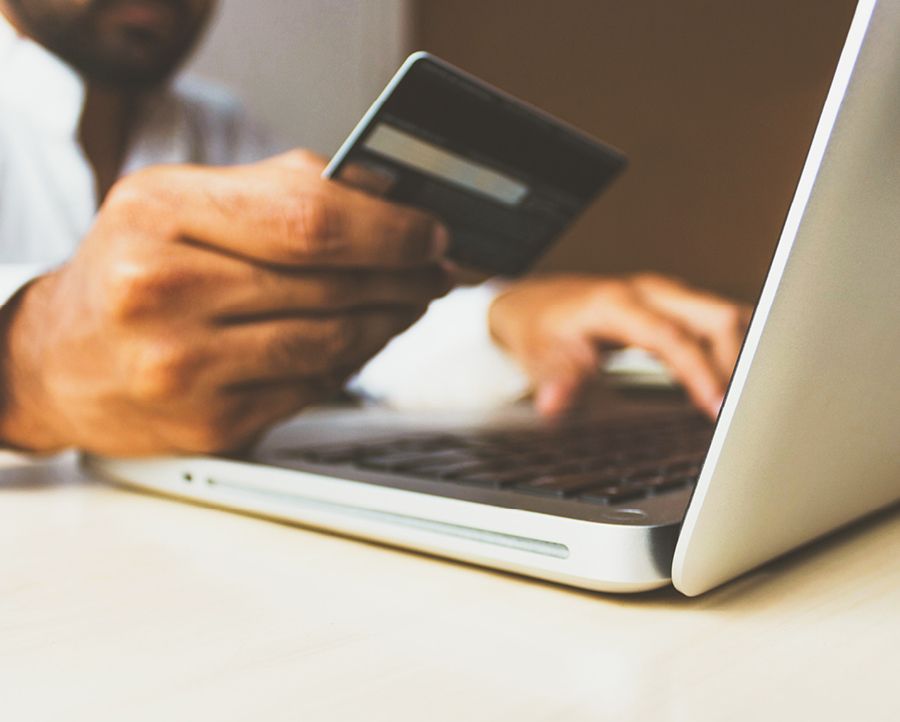A man pays his bills online using a credit card.